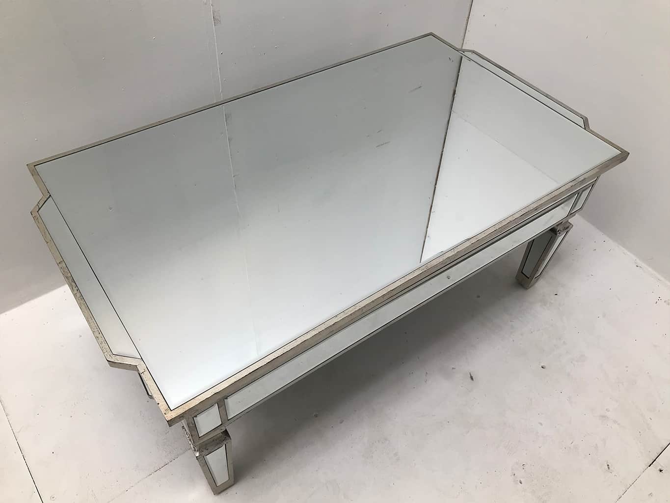 Mirrored coffee table with an antiqued silver wooden edging with a bevelled mirror top