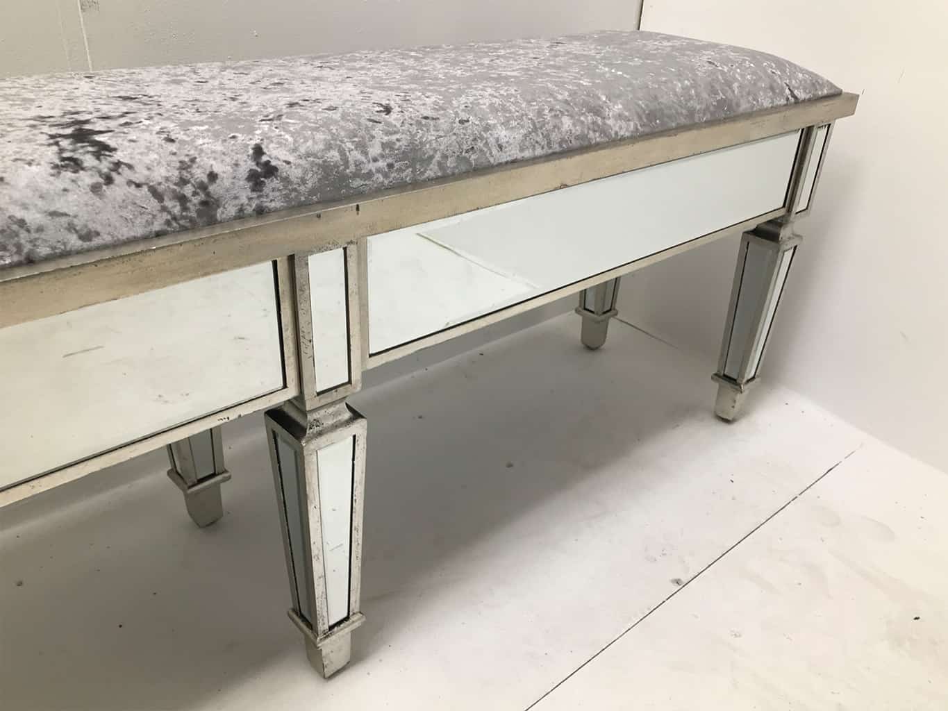 Charleston Mirrored extra long bench with all bevelled mirror panels, upholstered in a silver crushed velvet fabric, supported on 6 legs, wood and mirror and cloth, antiqued silver finish.