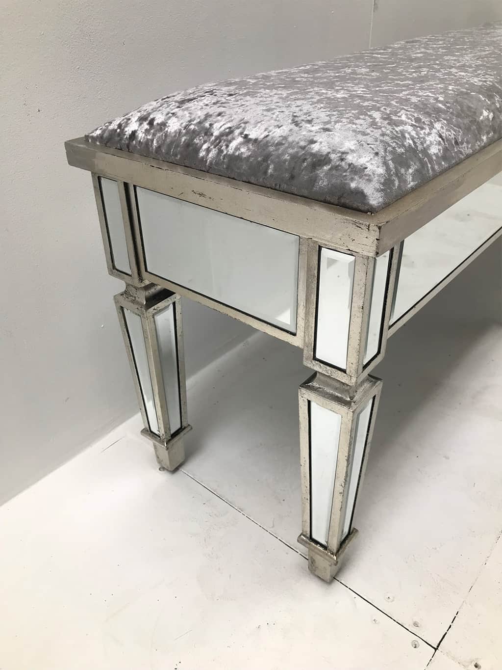 Mirrored Stool, extra long with all bevelled mirror panels, upholstered in a silver crushed velvet fabric, supported on 6 legs, wood and mirror and cloth, antiqued silver finish.