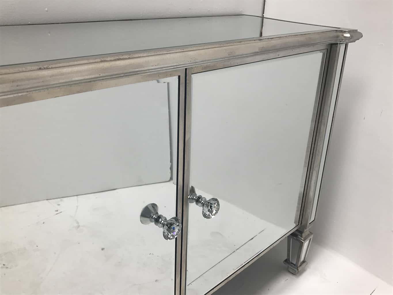 Mirrored sideboard with 2 cupboard doors, bevelled panels, curved ends, crystal knobs, wood and mirror, antiqued silver