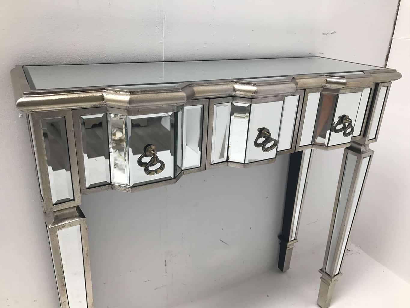 mirrored console table with 3 drawers, vintage style, slim design, silver wood edging, glass top, tapered legs and drop ring brass pulls